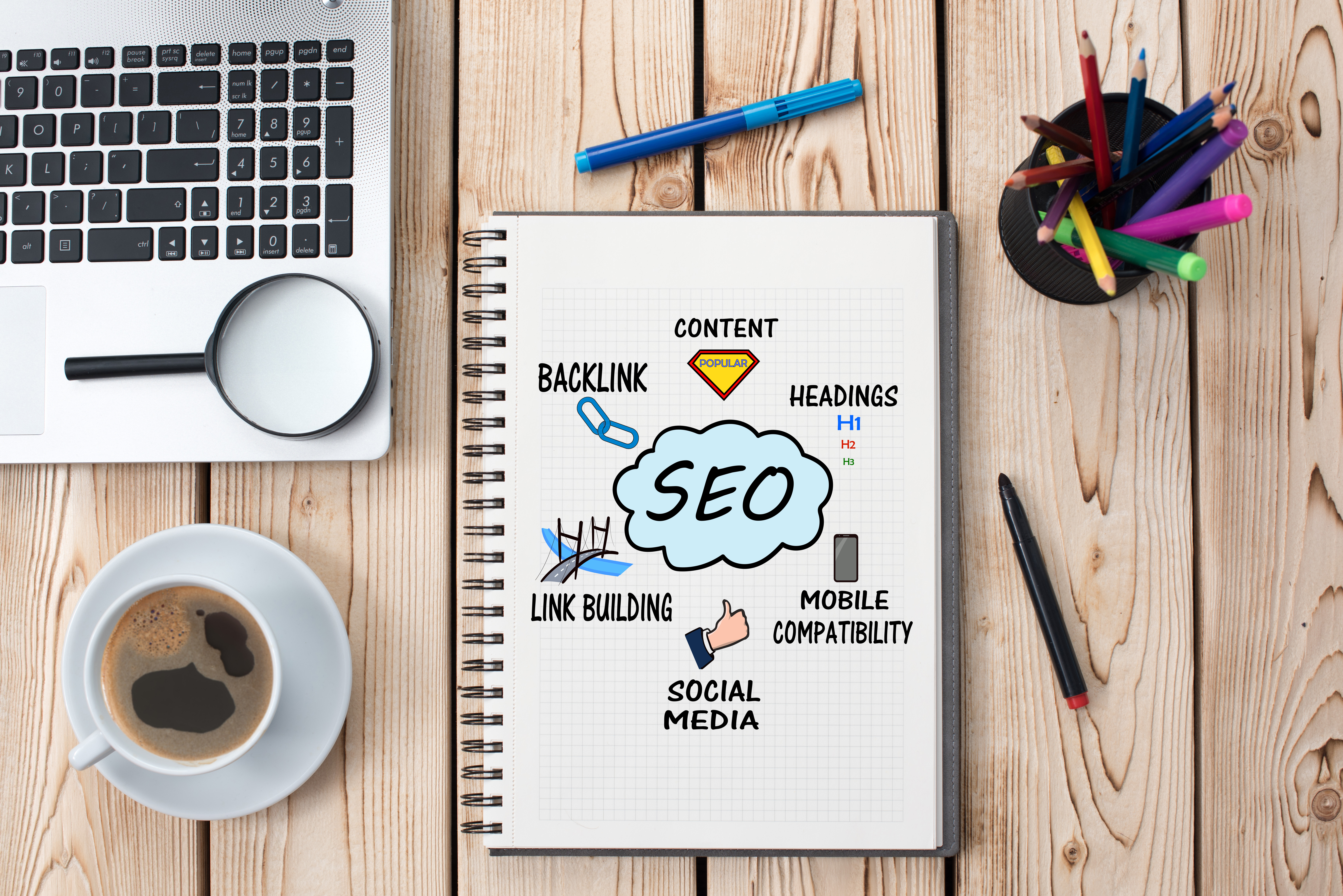 Overview of aspects of SEO in a book, next to an open laptop